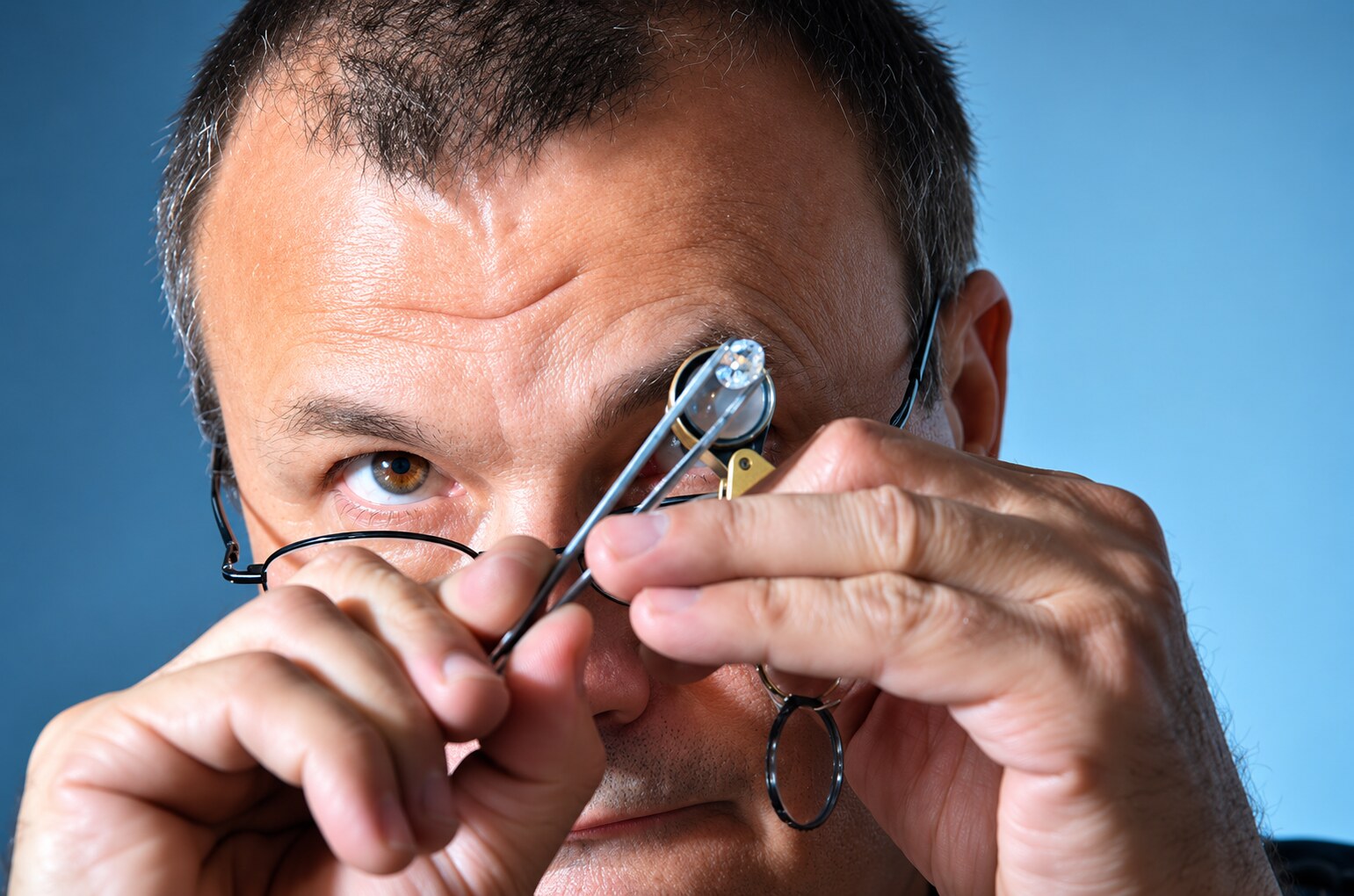 Master jeweler George Necula examining a diamond through a loupe